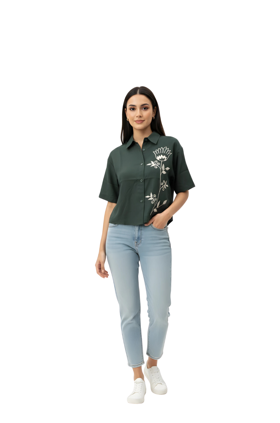 Woman wearing a green shirt with floral embroidery and light blue jeans on a white background