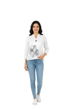 woman wearing white oversized embroidered top with black floral motif from Hava Fashions