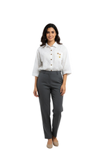 Woman wearing a white shirt with buttons and gray pants on a white background
